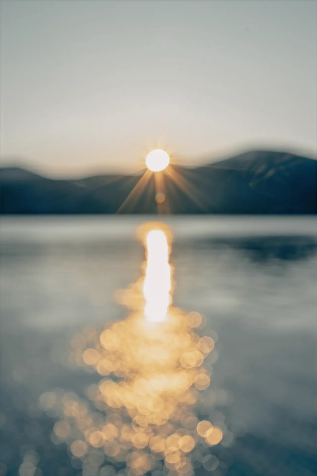 Sunrise over Lake George with warm clay-toned light on calm water